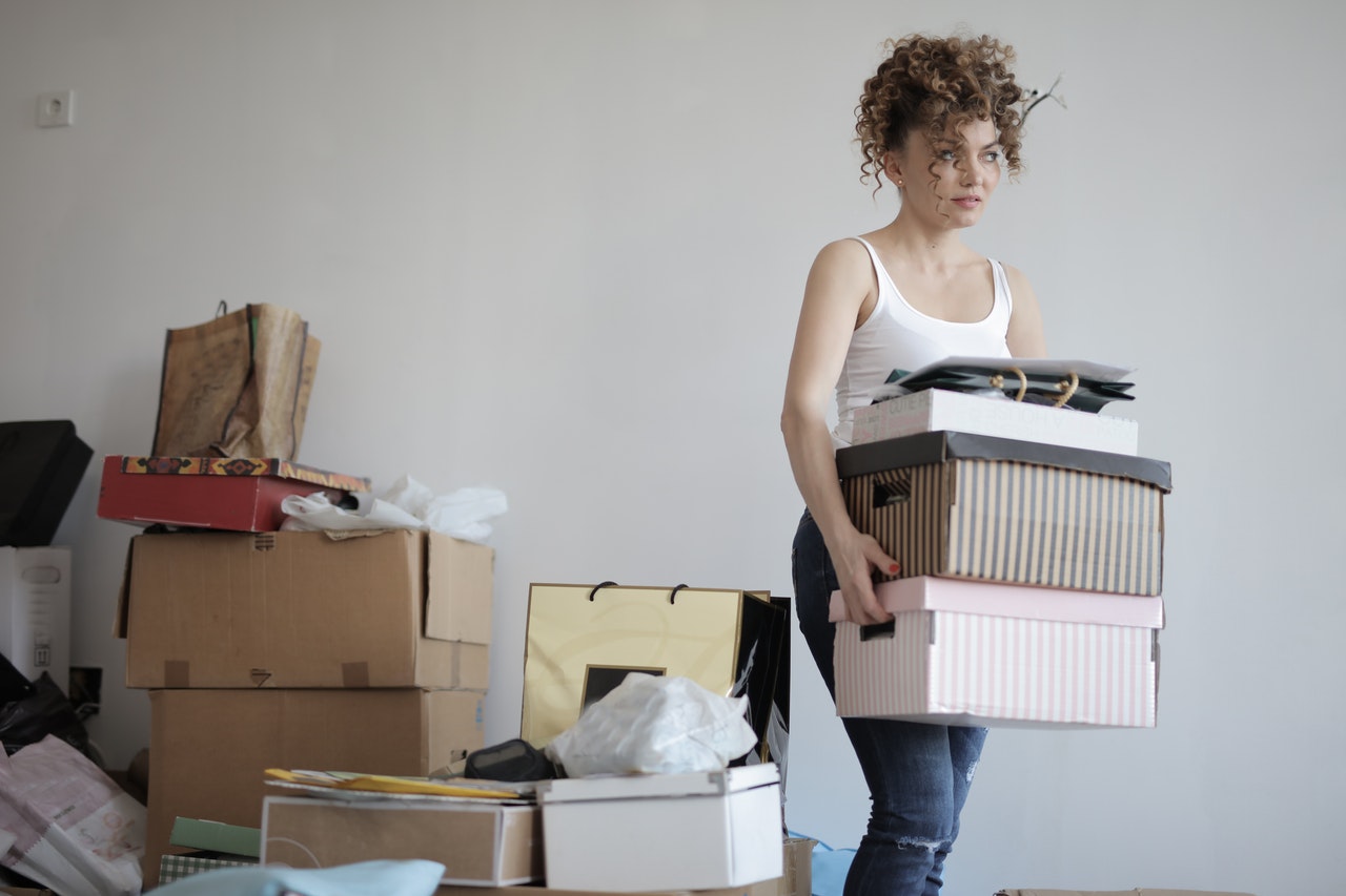 A woman carrying moving boxes