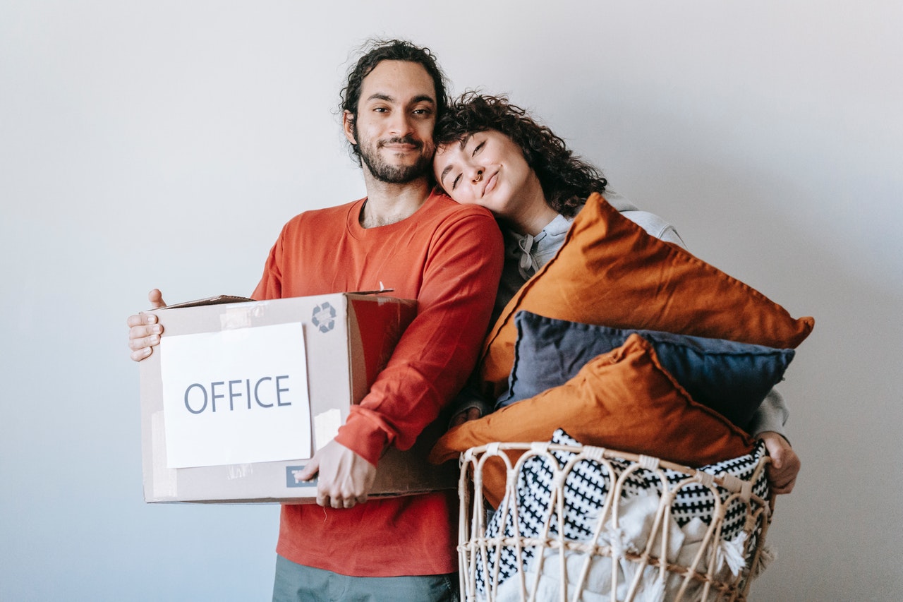 a man and woman holding items for moving