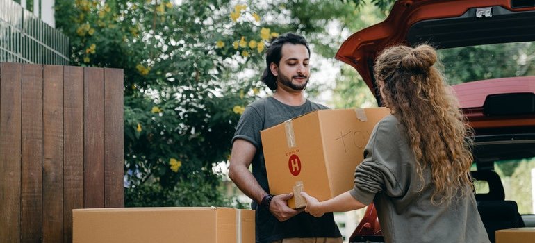 man and woman carrying a box