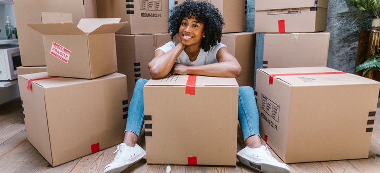 woman sitting in front of moving boxes