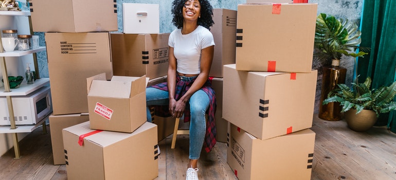 woman sitting surrounded by boxes waitng for packing service Tampa