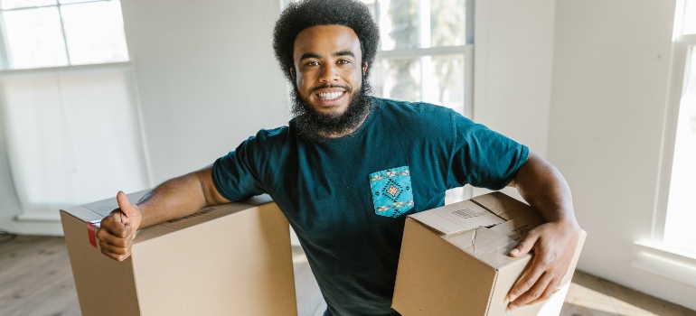 happy man holding moving box