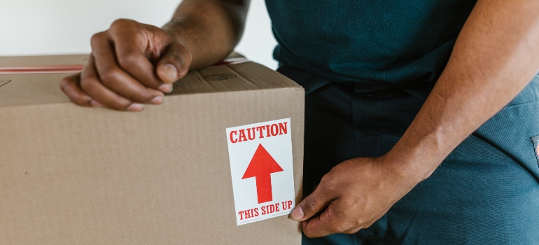 a man sealing cardboard moving box