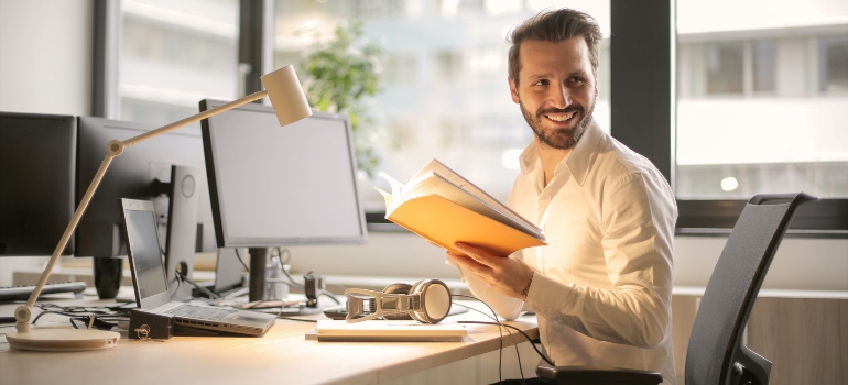 a man in the office holding a book