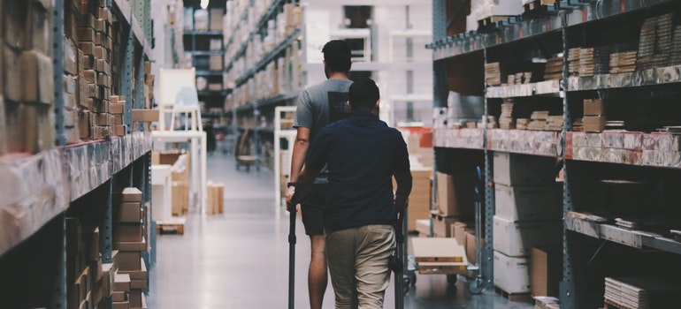 Two man walking around a warehouse while thinking about mistakes when renting storage;