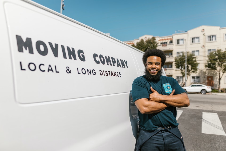 A man in green shirt leaning on a white van;