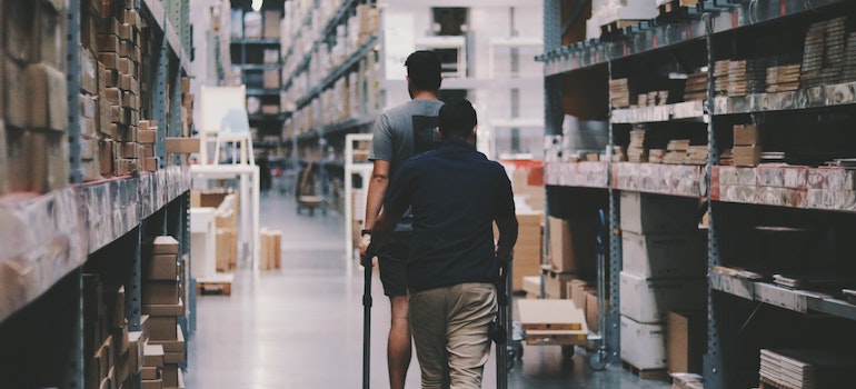 Two men going around a warehouse; 