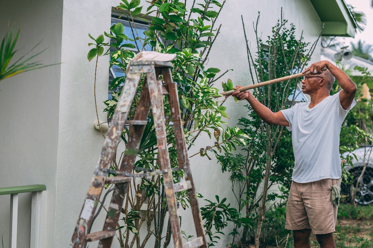 A man doing some renovations on his house outside.