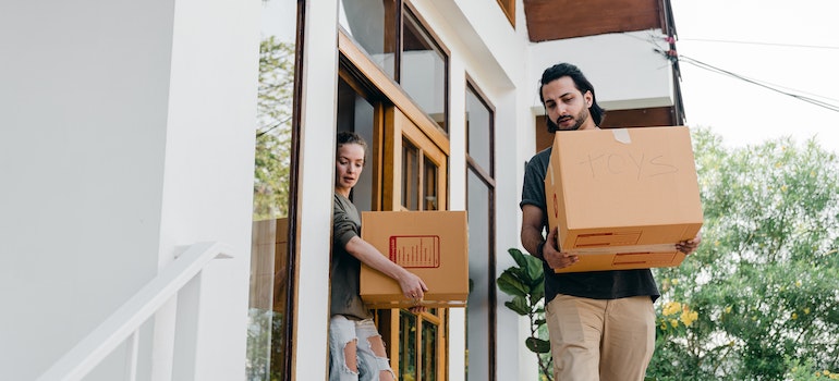 People carrying moving boxes down the stairs