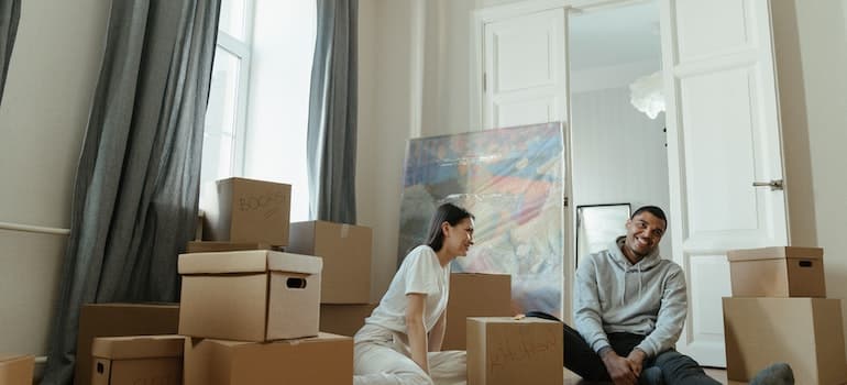 A couple sitting in the living room surrounded by boxes, while discussing clever tips on finding the right storage unit in Florida;