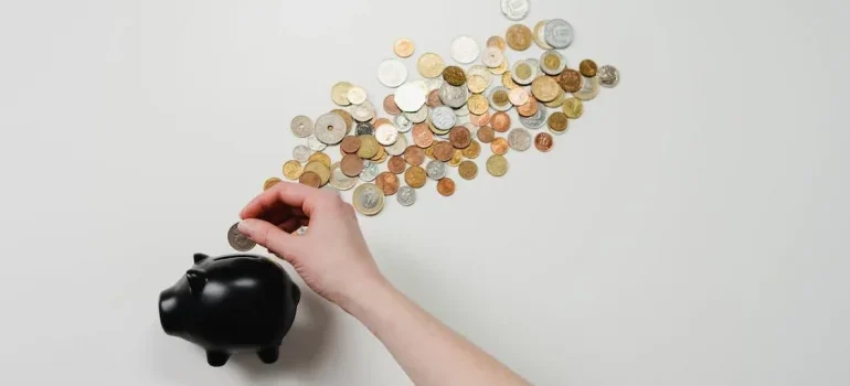 A person putting coins in a piggy