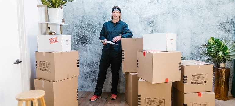 A man standing near moving boxes