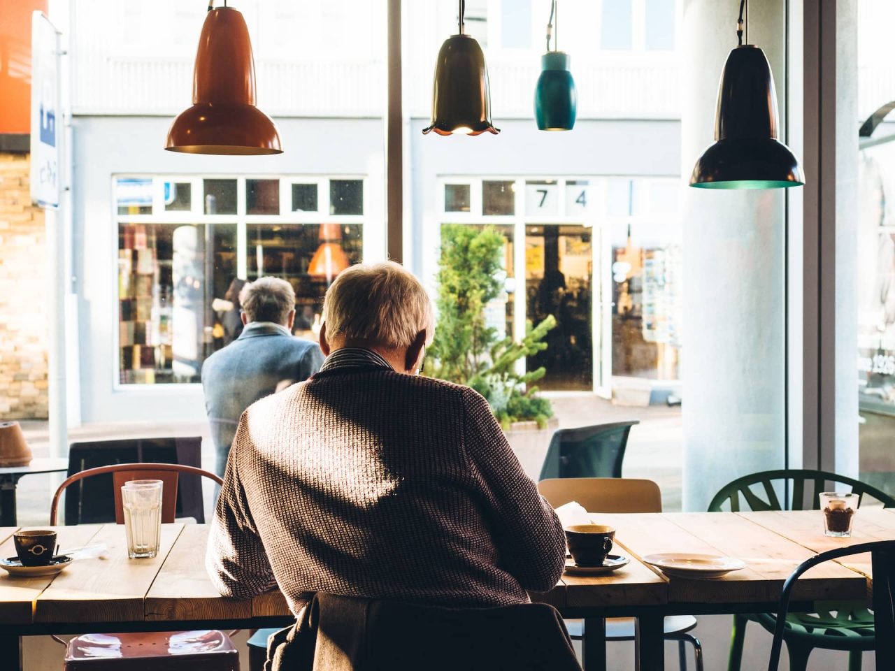 An old man reading newspapers at the coffee shop