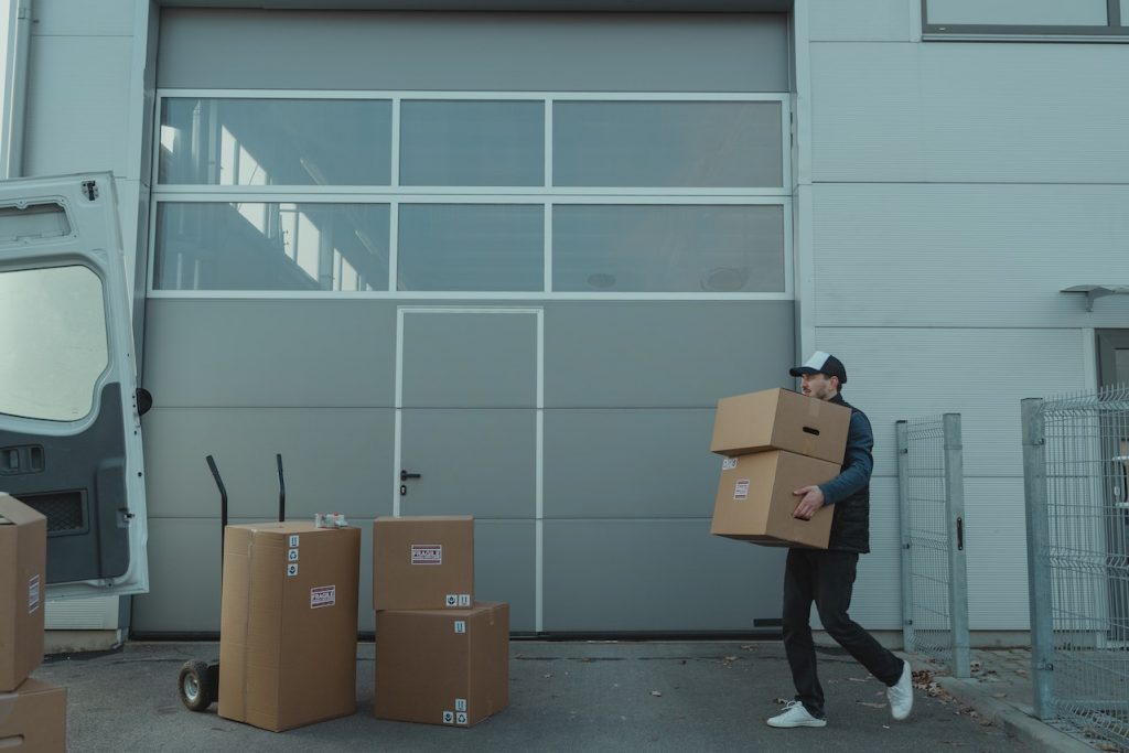 A man carries two moving boxes