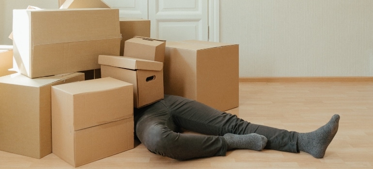 man covered with boxes