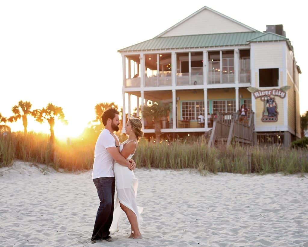 A couple in front of a beach house enjoying beachfront living in Space Coast
