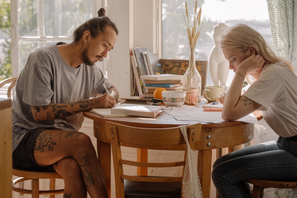 two people sitting and working as a representation of a nice life after moving in with roommates in Melbourne FL