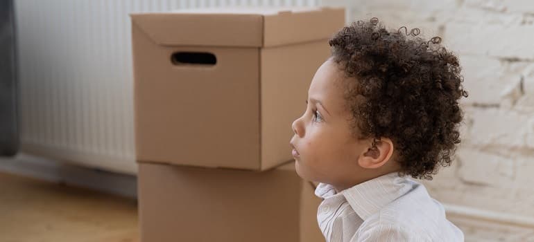 a child next to moving boxes