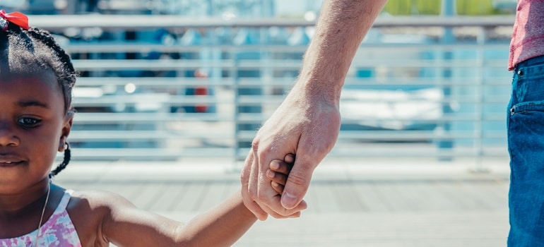 a single dad and his daughter holding hands